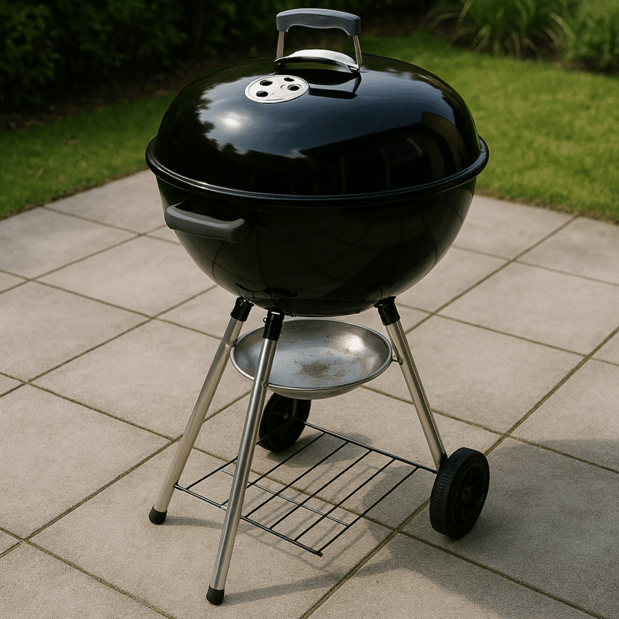 Ein Kugelgrill der auf Betonplatten im Garten steht.