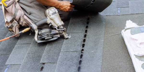 Roofer,Uses,An,Air,Pneumatic,Nail,Gun,To,Attach,New
