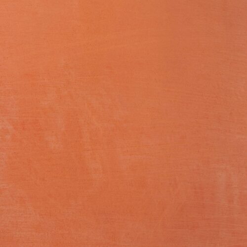 Terrakottafarbene Wand mit leicht unregelmäßiger, strukturierter Oberfläche.