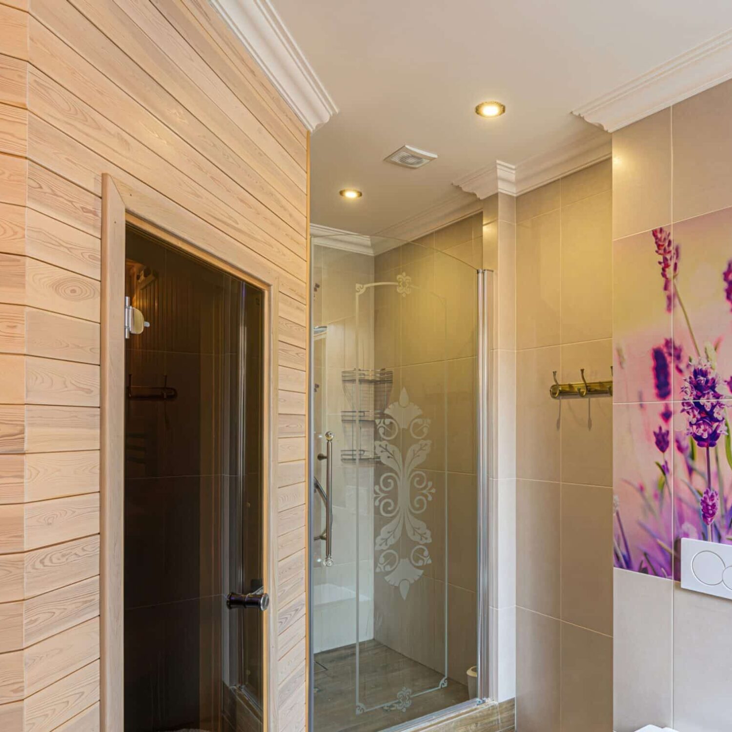 Modern,Bathroom,With,Lavender,Decor,,A,White,Sink,,Wooden,Shelves, Badezimmer mit Sauna aus Holz, Glastür zur Dusche mit Muster, weißer Toilette und großem Bild mit lila Lavendelblüten an der Wand.