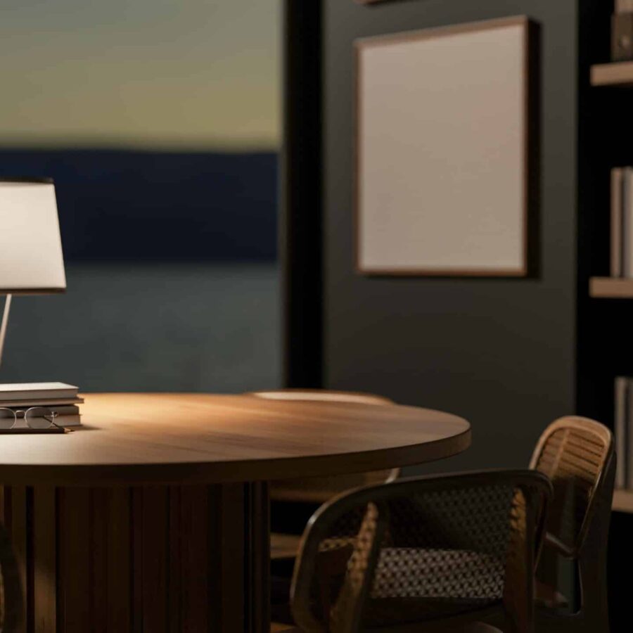 Tisch aus Holz auf der eine Lampe und eine Pflanze stehen. Im Hintergrund ist ein Bücherregal aus Holz und 2 Stühle aus Holz.